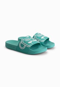 Aqua slide sandals with a textured strap featuring a white graphic design. Made of rubber, with a flat sole and open toe.