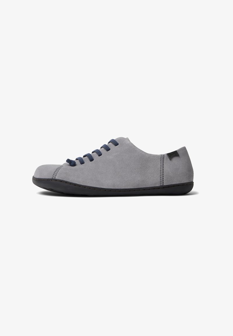 Hall gray suede king with rounded toe, navy shoelaces, minimalist design, and black rubber sole. Lacking a heel and featuring a smooth texture.