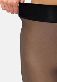 Sheer brown tights with a black elastic waistband, smooth texture, and a fitted design, showcasing a subtle gradient effect.