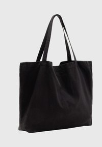 Fekete vászontáska két erős fogóval, szerkezet nélküli kialakítással és puha tapintással. Látható logók vagy díszítések nélkül.