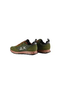 Scarpe da atletica verdi con tomaia in suede e mesh, caratterizzate da un logo bianco, lacci arancioni e una suola marrone testurizzata con motivi triangolari.