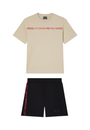 T-shirt beige a maniche corte con logo EA7 Emporio Armani rosso e pantaloncini neri con striscia rossa e marchio abbinati sul lato.