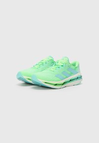 Light green running shoes with a breathable mesh upper, padded collar, and blue accents. Thick cushioned midsole and textured outsole.