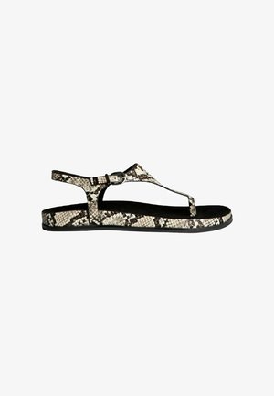 Sandalia plana de mujer con estampado de piel de serpiente en blanco y negro, correa ajustable en el tobillo y diseño con entrededo.
