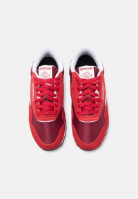 Κόκκινα αθλητικά παπούτσια με μίγμα από σουέντ και δίχτυ, στρογγυλερή μύτη, χοντρά κορδόνια και επενδεδυμένο κολάρο. Λογότυπο Reebok στη γλώσσα.