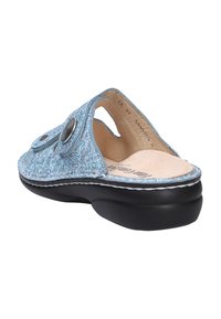 Light blue textured slip-on sandal with two adjustable straps, beige insole, and thick black sole, shown from a rear side angle.