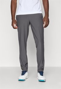 Gray athletic trousers with a smooth texture, tapered fit, and crease detail. Paired with white sneakers featuring blue accents.