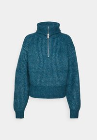 Pull en tricot vert menthe avec un col montant et une fermeture éclair mi-longue. Il présente des manches larges et un ourlet court. Tissu texturé avec un motif côtelé.