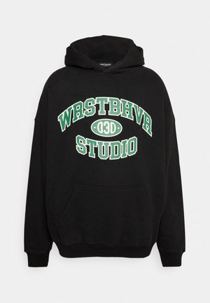 Sweat à capuche noir avec texte vert et blanc "WRSTBHVR 03D STUDIO" sur la poitrine et une poche kangourou à l'avant, présenté sur un fond uni.