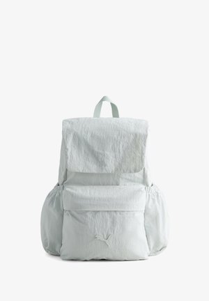 Sac à dos blanc Puma avec rabat supérieur, poche zippée à l'avant, poches latérales et petite poignée en boucle en haut sur fond blanc.