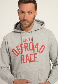 Felpa grigia con stampa rossa "DESERT OFFROAD RACE", cordini regolabili e tasca a marsupio frontale. Tessuto morbido.