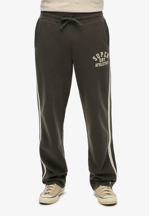 Grå sweatpants med elastisk talje, forlommer, lyse striber og trykt tekst i en kontrastfarve. Har en afslappet pasform.