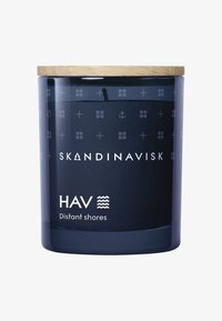 Blaue Glaskerze mit einem Deckel aus natürlichem Holz, versehen mit einem Etikett, das "SKANDINAVISK" und "HAV Distant shores" liest, mit dezenten grafischen Mustern.
