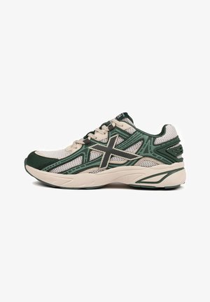 Green and white athletic shoe featuring a mesh upper, reinforced toe, layered design, and textured sole with subtle accents and stitching details.