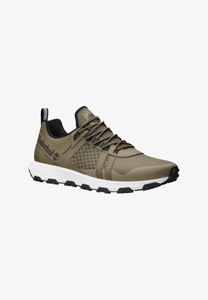 Hellbraunes Athletikschuh-Modell mit strukturiertem Mesh-Obermaterial, schwarzen Akzenten und verstärktem Absatz. Verfügt über eine weiße Zwischensohle und eine Gummisohle.