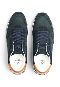 Sneakers in suede blu navy con punta tonda, lacci blu navy e un accento in pelle marrone sul tallone. Suola bianca e interno strutturato.