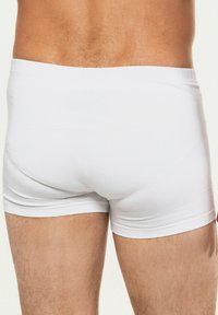Bílé boxerky z měkké tkaniny, s těsným střihem a hladkým povrchem, s elastickým páskem nahoře.