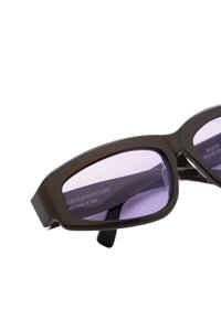 Occhiali da sole in plastica marrone con montature rettangolari e lenti color viola. Presentano una superficie liscia e un logo discreto sul lato interno.