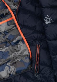 Giacca imbottita con un rivestimento esterno blu navy, fodera camouflage grigia e blu, dettagli arancioni e zip su tasche e davanti.