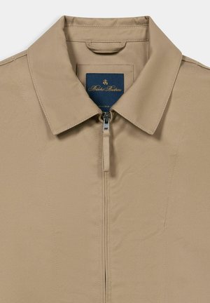 Beige Jacke mit Kragen, vorn mit Reißverschluss und Brooks Brothers Etikett im Krageninnenteil.