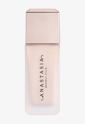 Mat glazen fles met een beige vierkante dop, gelabeld met "Anastasia Beverly Hills" in zwarte verticale tekst.