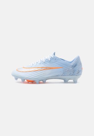 Crampon de football bleu clair avec des lacets blancs, un swoosh orange Nike et une semelle cloutée pour terrain ferme, montré de profil sur fond blanc.