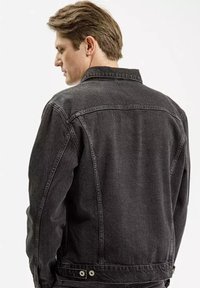 Czarna kurtka dżinsowa z klasycznym kołnierzem, widocznymi szwami i regulowanymi bocznymi paskami. Posiada stonowany krój i gładki tył.