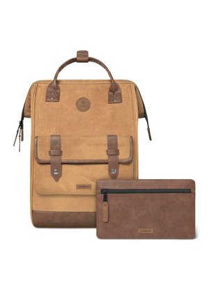 Tan canvas backpack with brown leather accents, featuring a top handle, front flap, and a small brown zippered pouch beside it.