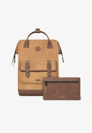 Tan canvas backpack with brown leather accents, featuring a top handle, front flap, and a small brown zippered pouch beside it.