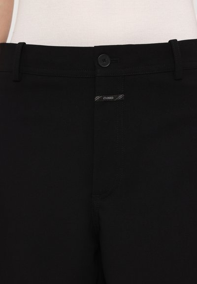 Black pants made of cotton blend fabric, featuring a button closure, a small label reading "CLOSED," and subtle stitching details.