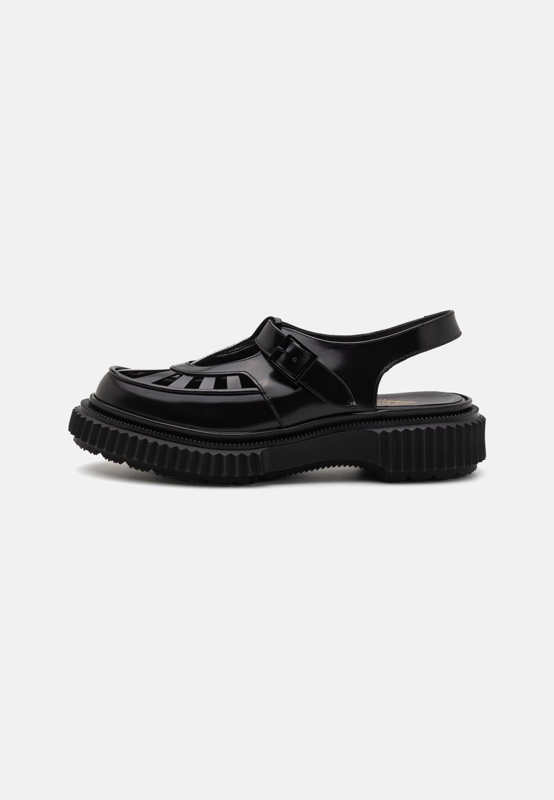 Black sandals with a glossy finish, featuring a slotted design, adjustable buckle, and a thick, ridged sole for added grip.