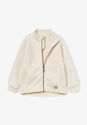 Kreemikarva fliisjope täis lukuga, soonikkoes mansettidega ja väike kangasbrändi silt ääre lähedal.