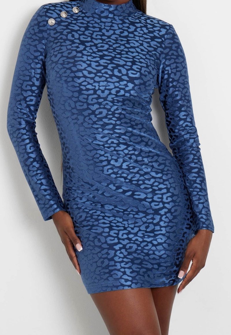 Robe courte ajustée à manches longues, imprimé animal bleu, avec trois boutons argentés sur l'épaule gauche.