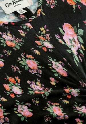 Black floral print dress featuring pink, orange, and green flowers. Material is soft with a slight sheen. Includes a round neckline and gathered detail.