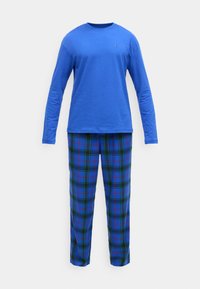 Modrá bavlnená košeľa s dlhým rukávom, v kombinácii s modrými károvanými pyžamovými nohavicami s zelenými a červenými akcentmi, poskytujúca pohodlný voľnočasový outfit.
