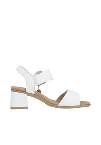 White open-toe sandals with a block heel, featuring wide straps and a rear ankle strap with a decorative charm. Smooth leather texture.