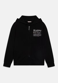 Schwarzer Zip-up-Hoodie aus weichem Material, mit Kapuze, gerippten Bündchen und grafischem Fronttext "HAPPY GUESS" in Weiß mit glitzernden Akzenten.