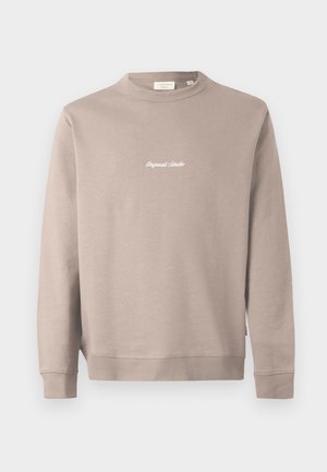 Beżowy sweter z długimi rękawami i okrągłym dekoltem. Na piersi haft "Original Studio" w białym kolorze. Gładka tekstura, ściągacze przy rękawach.