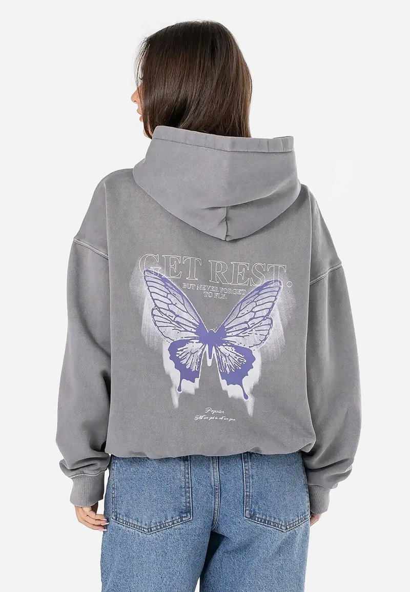 Pilkas didelis hoodie su dideliu purpuriniu drugelio piešiniu ir tekstu ant nugaros. Pagamintas iš minkštos medžiagos, turi kengūrinę kišenę.