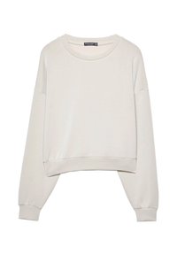 Biały skrócony sweatshirt wykonany z miękkiego materiału, z okrągłym dekoltem, rękawami na opadających ramionach i ściągaczami. Prosty i minimalistyczny design.