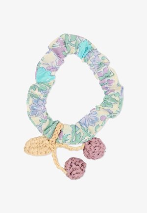 Chouchou en tissu floral pastel avec deux pompons décoratifs tissés, de couleur brun clair et mauve, attachés.