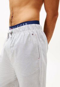 Herenshort met strepen voor in de lounge, met een verstelbare marineblauwe tailleband met het merkembleem. Gemaakt van lichte stof en met een ontspannen pasvorm.