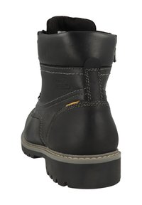 Botín negro de cuero con costuras grises, suela de goma, tacón reforzado y cierre de cremallera en el lateral. Acabado texturizado.