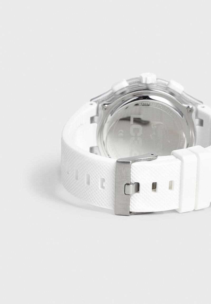 Orologio da polso bianco con cinturino testurizzato, fibbia argentata e retro in metallo lucido, visto da dietro su uno sfondo chiaro e semplice.