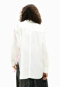 Valge pikkade varrukatega särk, sirge lõikega, seljaõmblusega ja roosade triipude aktsentidega varrukatel. Sujuv tekstuur.