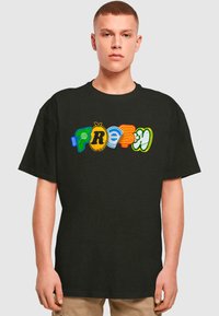 Svart T-skjorte med fargerik "FRESH" tekst i varierte design: grønn globe, gul pære, lyseblå bølger, rød og grønn akcent.