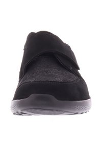 Zwarte schoen met een klittenbandsluiting, voorzien van een gestructureerde bovenkant en een flexibele rubberen zool, die een naadloos ontwerp en een slanke silhoeët biedt.