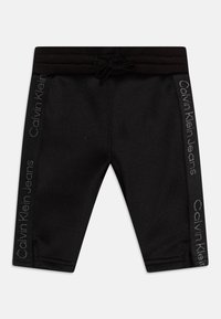 Shorts neri elasticizzati con vita elastica e coulisse, con logo in rilievo "Calvin Klein Jeans" sui lati.