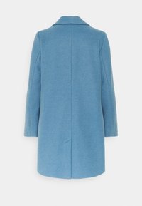 Figurerad ljusblå ullkappa med spetsig krage, långa ärmar och rak skärning. Har en mittslits bak.