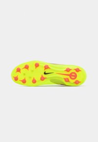 Nike fodboldstøvlers sål i lys gul med pink accenter og flere runde studs for greb. Har et sort logo på siden.